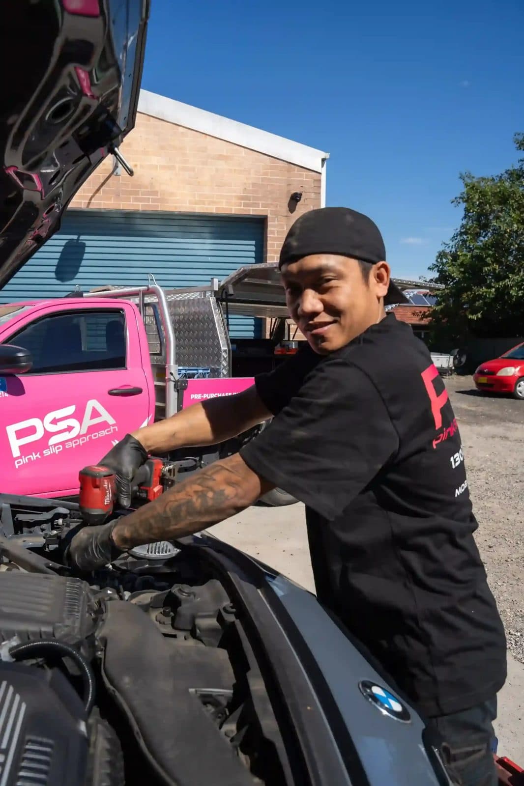 A PSA technician working in a car’s engine bay