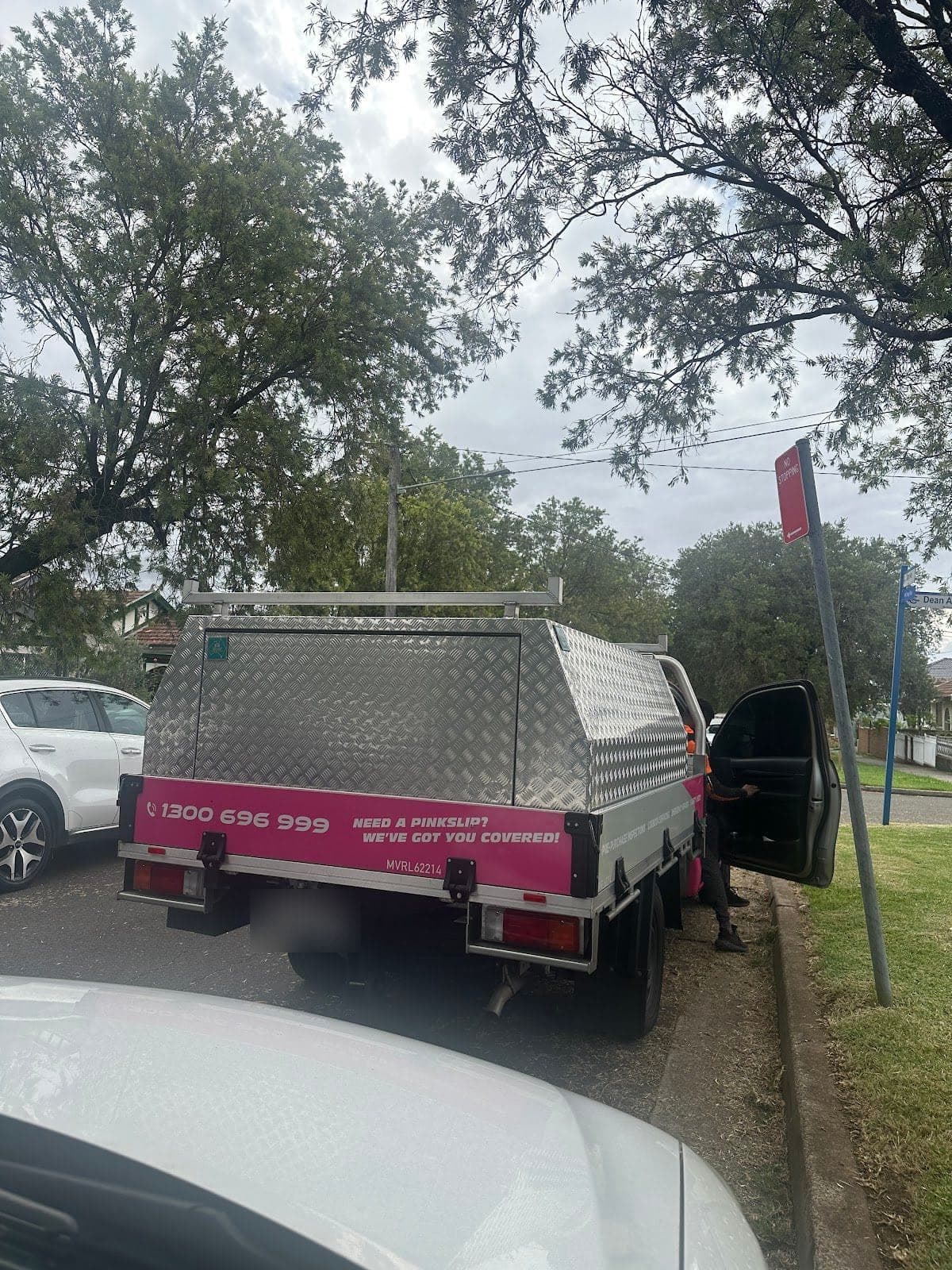 The back of a PSA service ute with its aluminium canopy, parked at the kerb under trees
