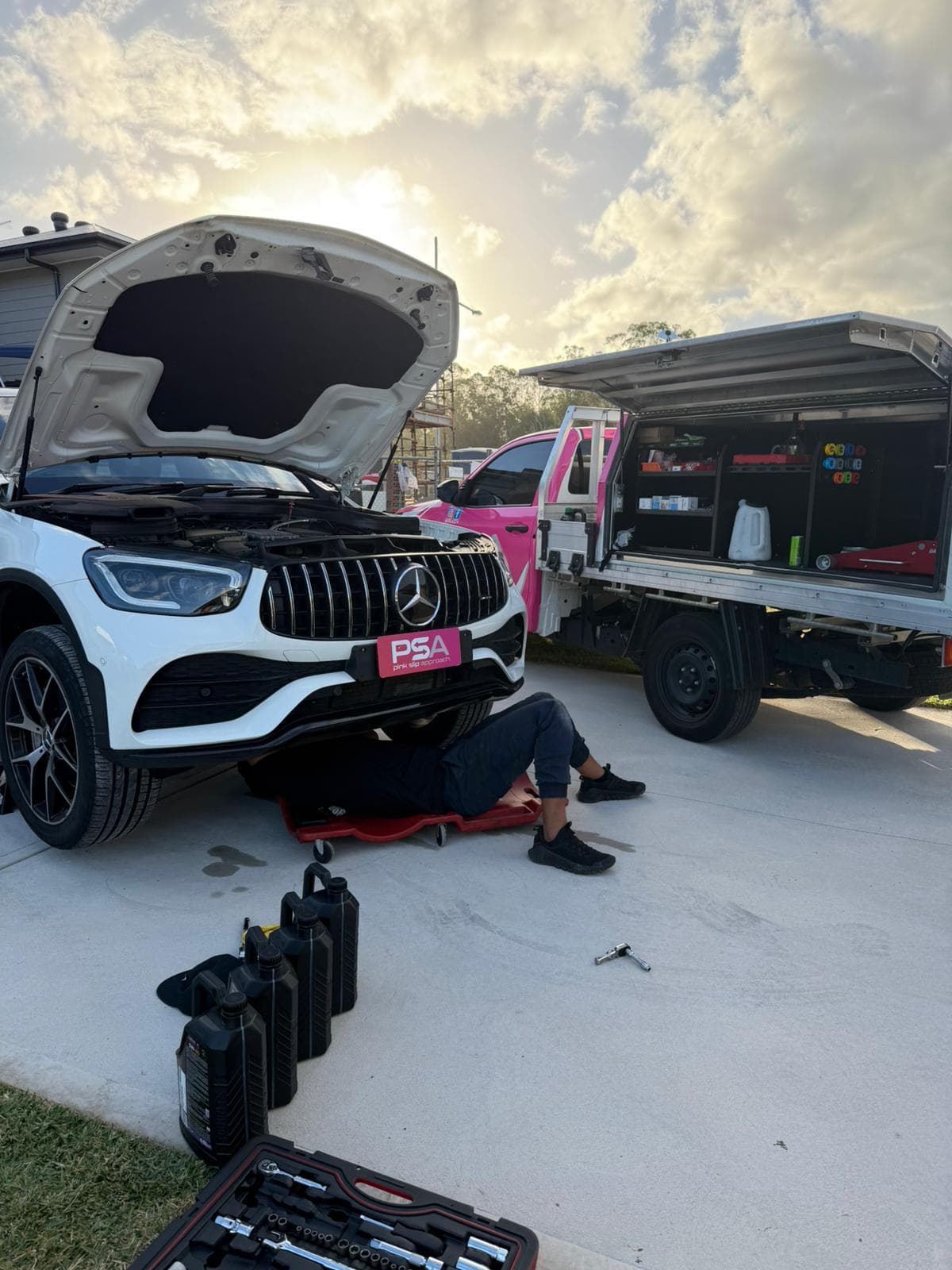A Pink Slip Approach technician inspecting a car on a home driveway